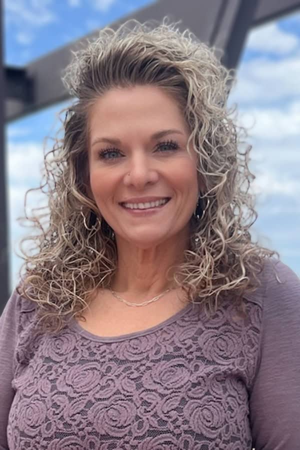 Portrait of Chantil Marlow with curly blonde hair and a friendly smile.